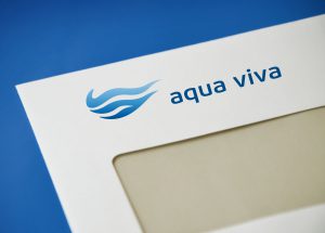 Detailansicht eines Kuverts mit dem Logo von Aqua Viva. Es zeigt ein blaues Wellenelement, welches in seiner Ganzheit ein Wassertropfen bildet.
