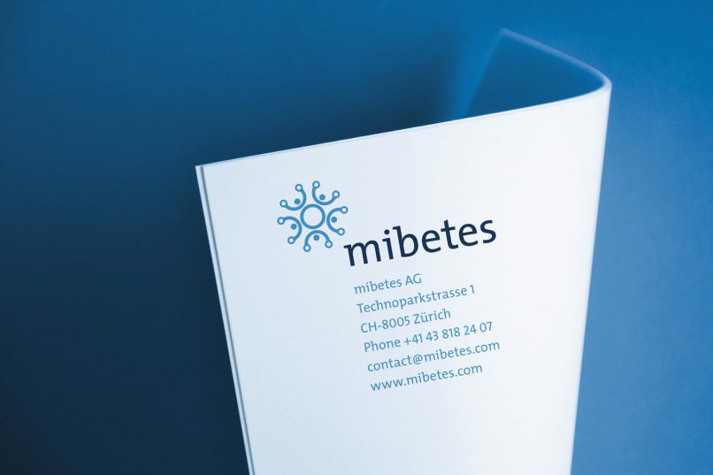Das Logo von Mibetes lehnt sich an das blaue Kreis Symbol für Diabetes an. Es wurde mit abstrahierten 5 Menschen erweitert, die die Hände in die Luft halten.