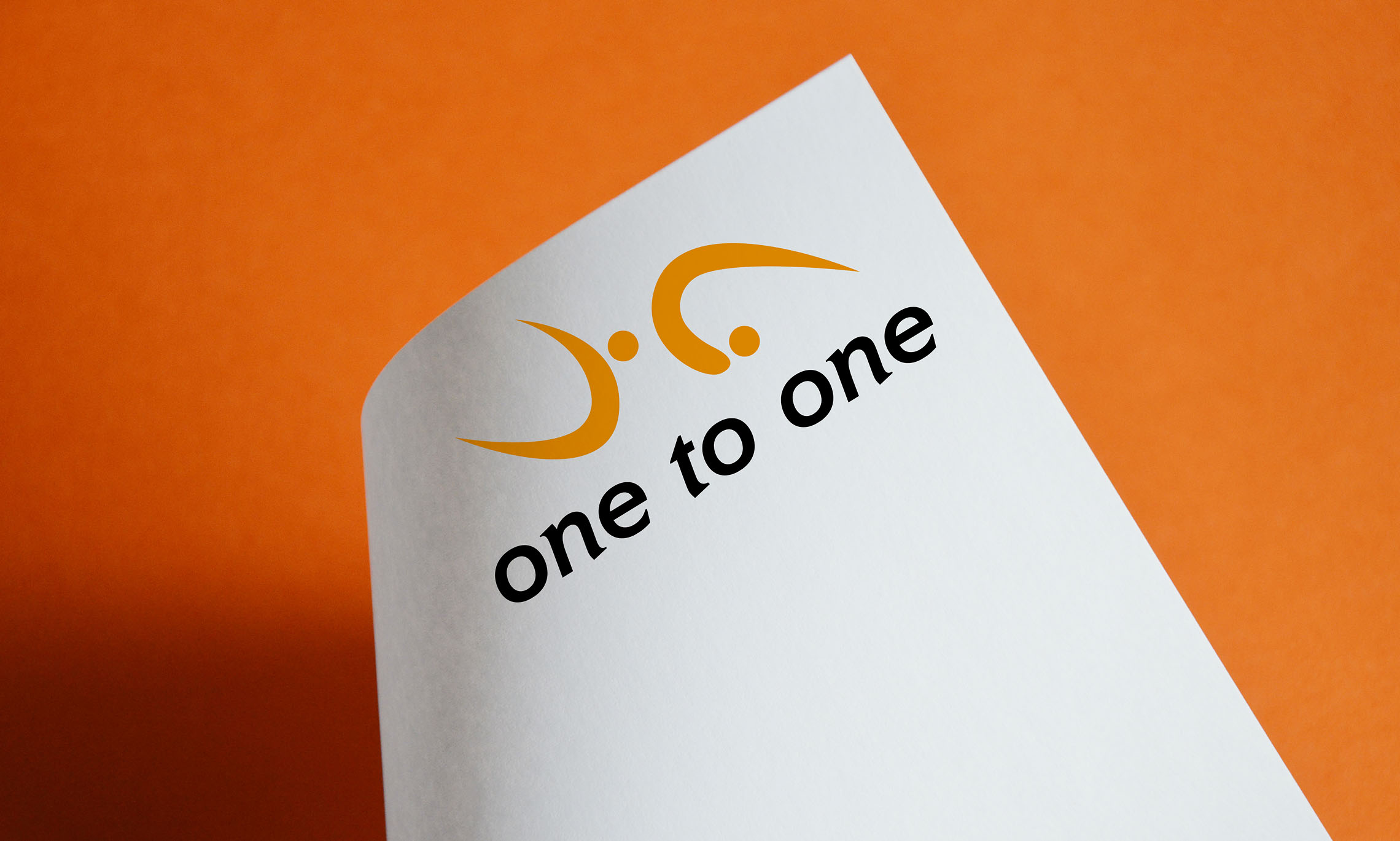 Das Logo für die Firma One to One Pilates zeigt zwei abstrahierte Personen in Turnübungen. Die Strichmännchen bestehen auf einer orangen Schwunglinie und einem Punkt als Kopf.